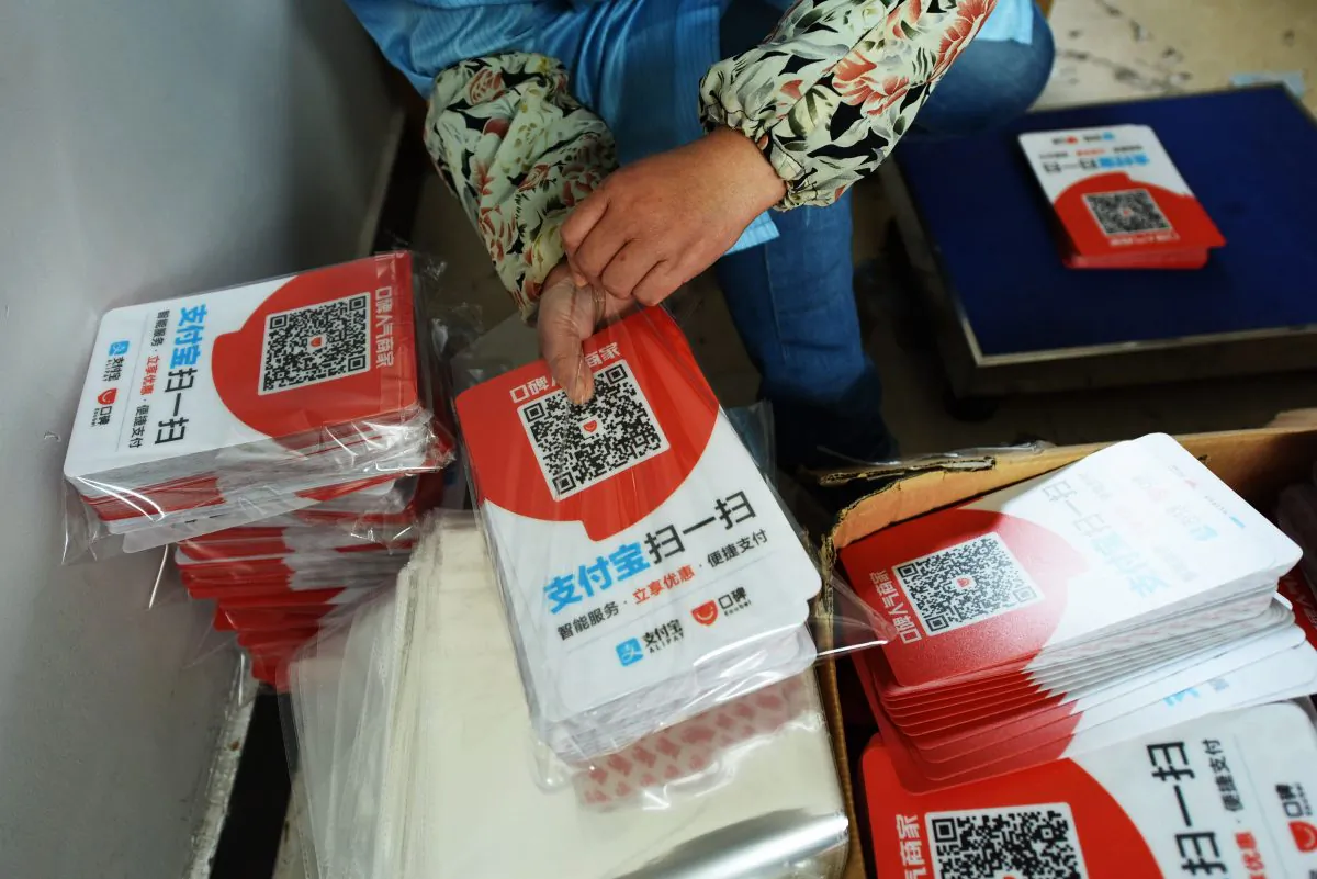 A worker packs newly printed cards showing Alipay QR codes for online payment at a printing factory in Hangzhou in China's eastern Zhejiang Province on July 16, 2018. (AFP/Getty Images)