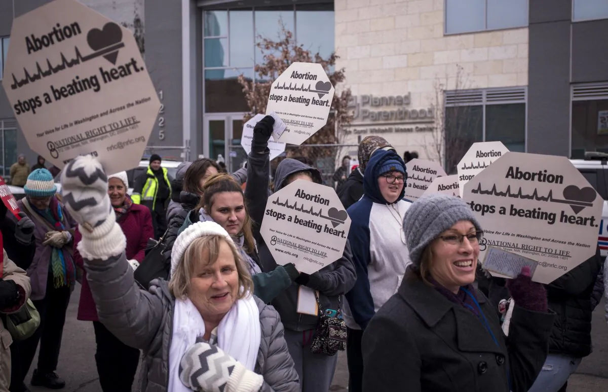 Demonstrators hold signs during a protest vigil sponsored by The Christian Defense Coalition and Priests for Life outside of the Planned Parenthood of Metropolitan Washington, D.C., Carol Whitehill Moses Center on Jan. 17, 2019. (Zach Gibson/Getty Images)