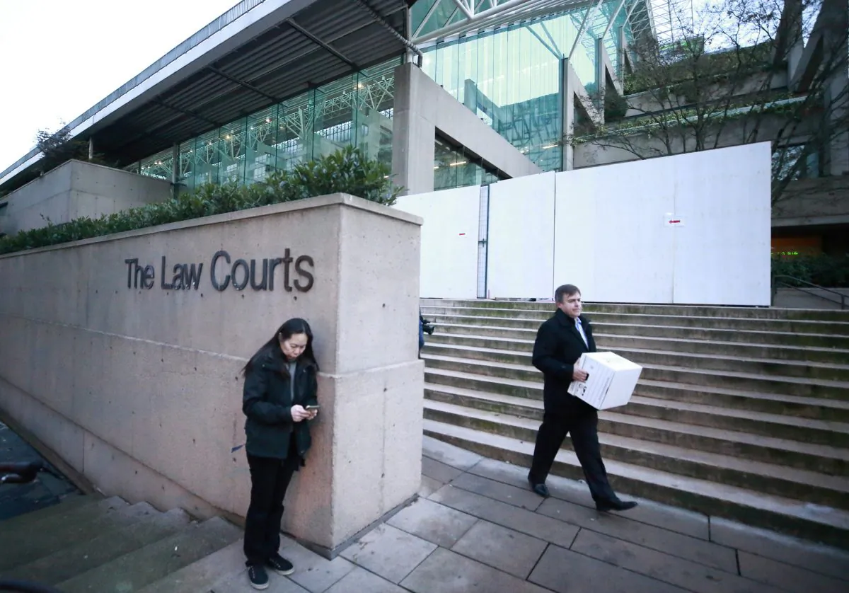 People stand outside the British Columbia Supreme Courthouse during a break in proceedings while attending the bail hearing for Huawei Technologies Chief Financial Officer Meng Wanzhou in Vancouver, Canada on Dec. 7, 2018. (Jeff Vinnick/Getty Images)