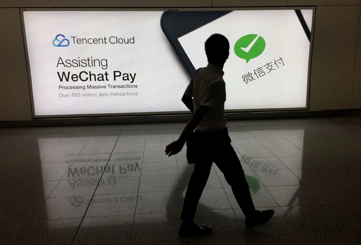 A man walks past an advertisement for the WeChat social media platform, owned by China's Tencent, at Hong Kong International Airport on Aug. 21, 2017. (Richard A. Brooks/AFP/Getty Images
