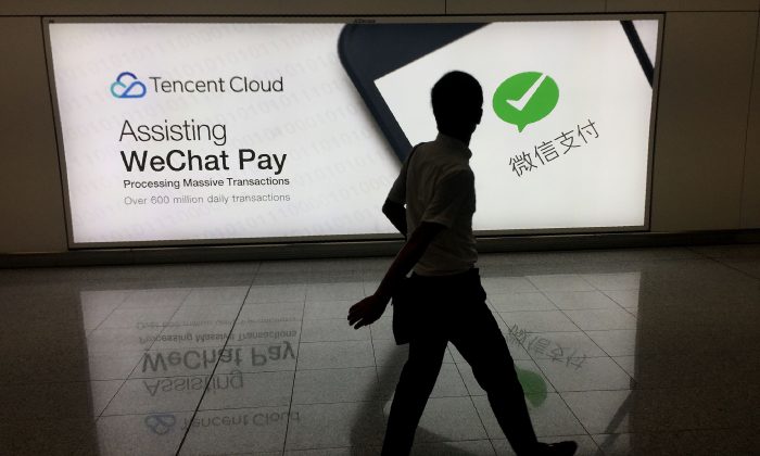 A man walks past an advertisement for the WeChat social media platform, owned by China's Tencent, at Hong Kong International Airport on Aug. 21, 2017.  (RICHARD A. BROOKS/AFP/Getty Images)