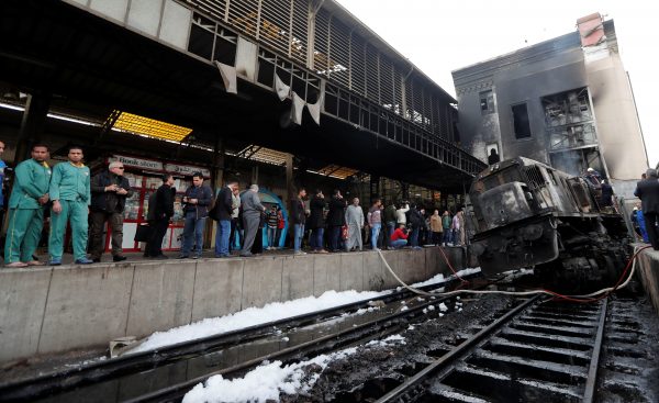 People gather at the main train station after a fire caused deaths and injuries, in Cairo