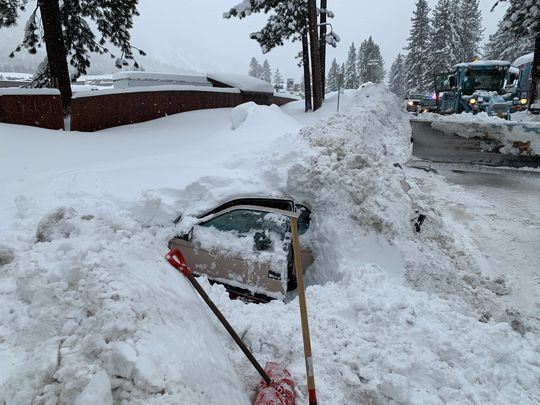 car buried in snow with woman inside