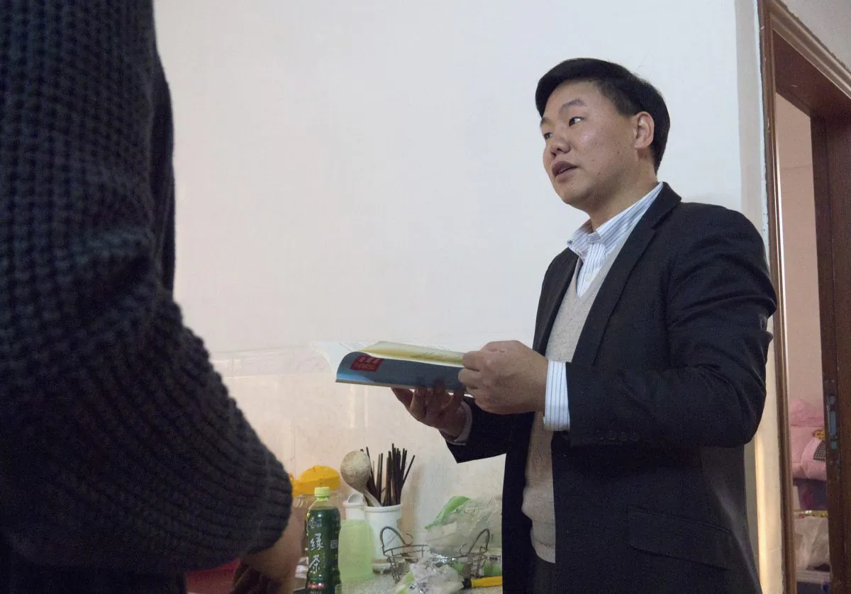 Zhang Zhiru, a prominent Shenzhen-based activist, holds a book before an interview in Guangzhou, Guangdong Province on Jan. 20, 2015. (Alexandra Harney/Reuters)