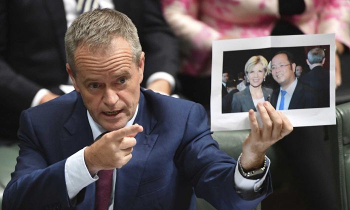 Australian Opposition Leader Bill Shorten holds a photograph of then-Australian Foreign Minister Julie Bishop with Chinese businessman Huang Xiangmo at Parliament House in Canberra, Australia, on June 14, 2017. (AAP Image/Lukas Coch)