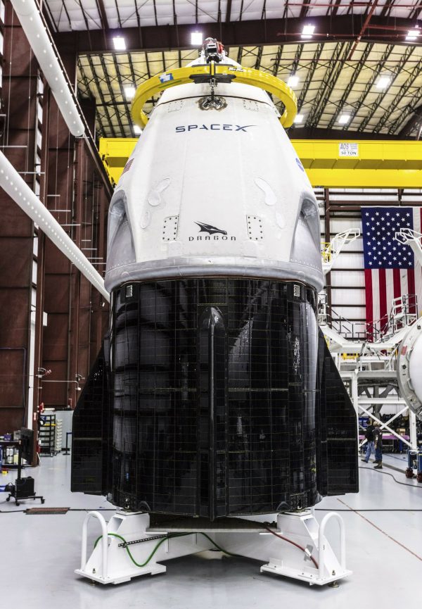 SpaceX's Crew Dragon spacecraft and Falcon 9 rocket are positioned inside the company's hangar