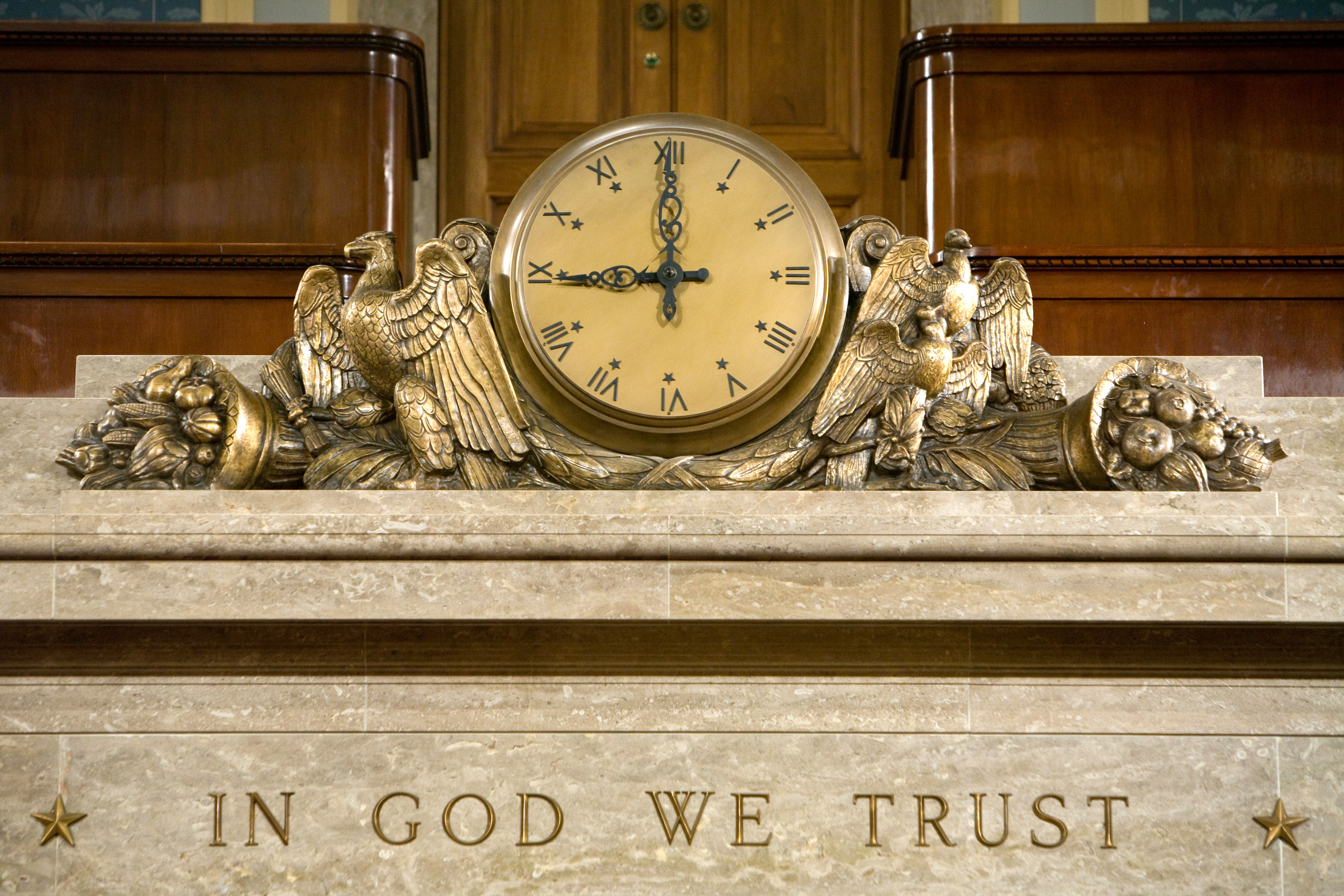 A clock and the motto "In God We Trust"