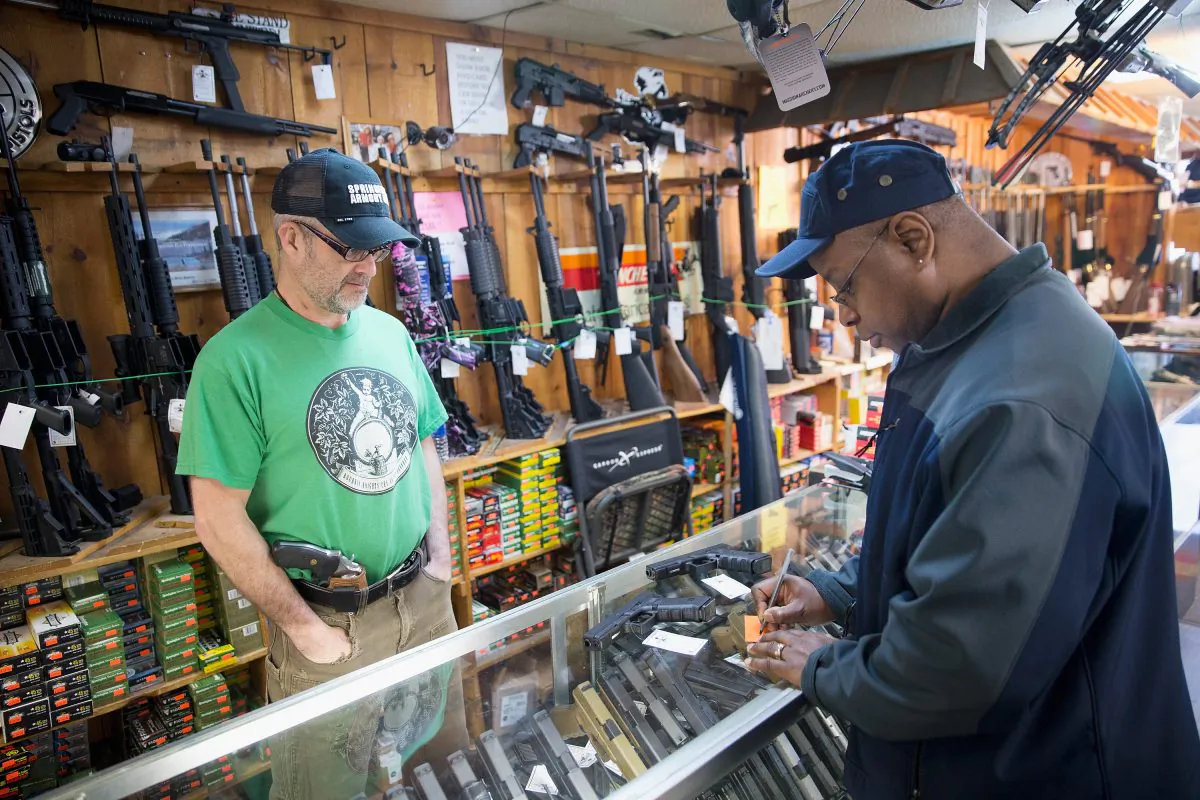 Danny Egan (L) helps a customer shop for a handgun at Freddie Bear Sports on March 11, 2015 in Tinley Park, Illinois. Scott Olson/Getty Images