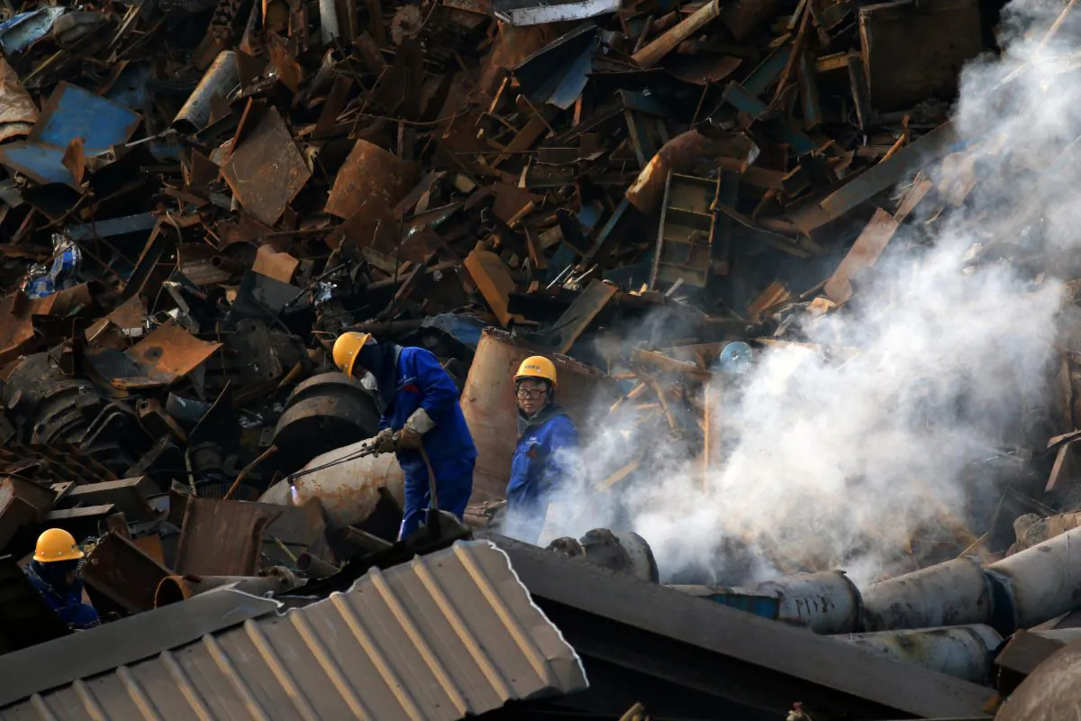 Workers dismantle scrap metal at a steel plant in Huaian, Jiangsu Province, China on March 4, 2019. (Reuters)