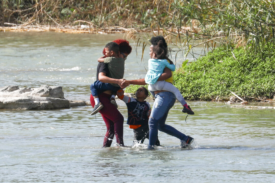 Two women and three children attempt to cross the Rio Grande from Mexico into the United States illegally near Eagle Pass, Texas, on Feb. 16, 2019. (Charlotte Cuthbertson/The Epoch Times)