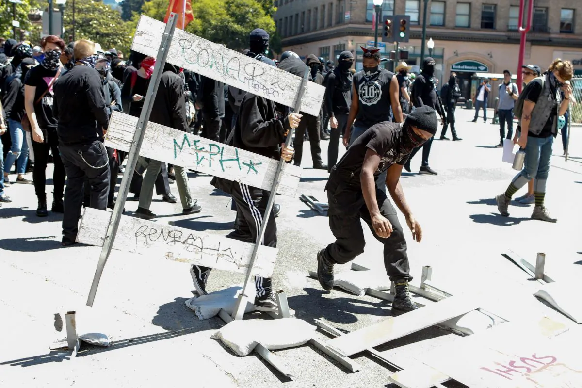 Antifa protesters knock down street barricades in downtown Berkeley, Calif., on Aug. 5, 2018. (Amy Osborne/AFP/Getty Images)