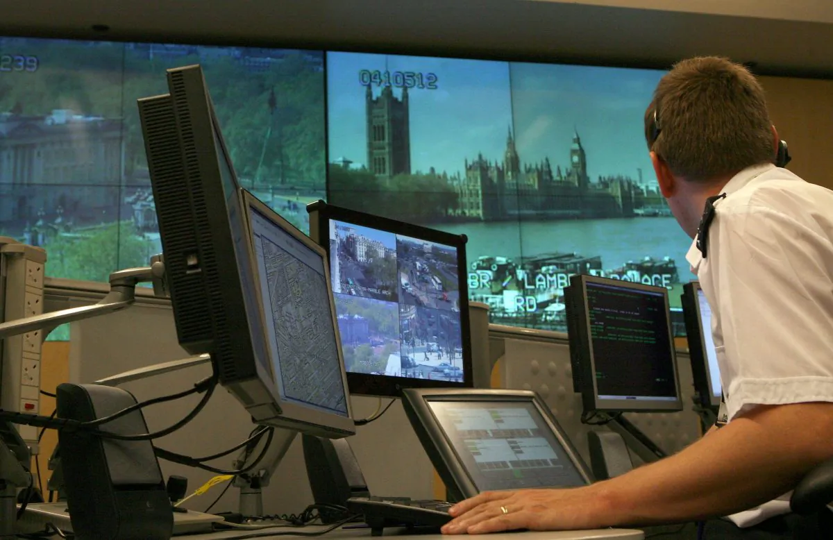 A police officer watches banks of television monitors in London on April 20, 2007.  (Matt Cardy/Getty Images)