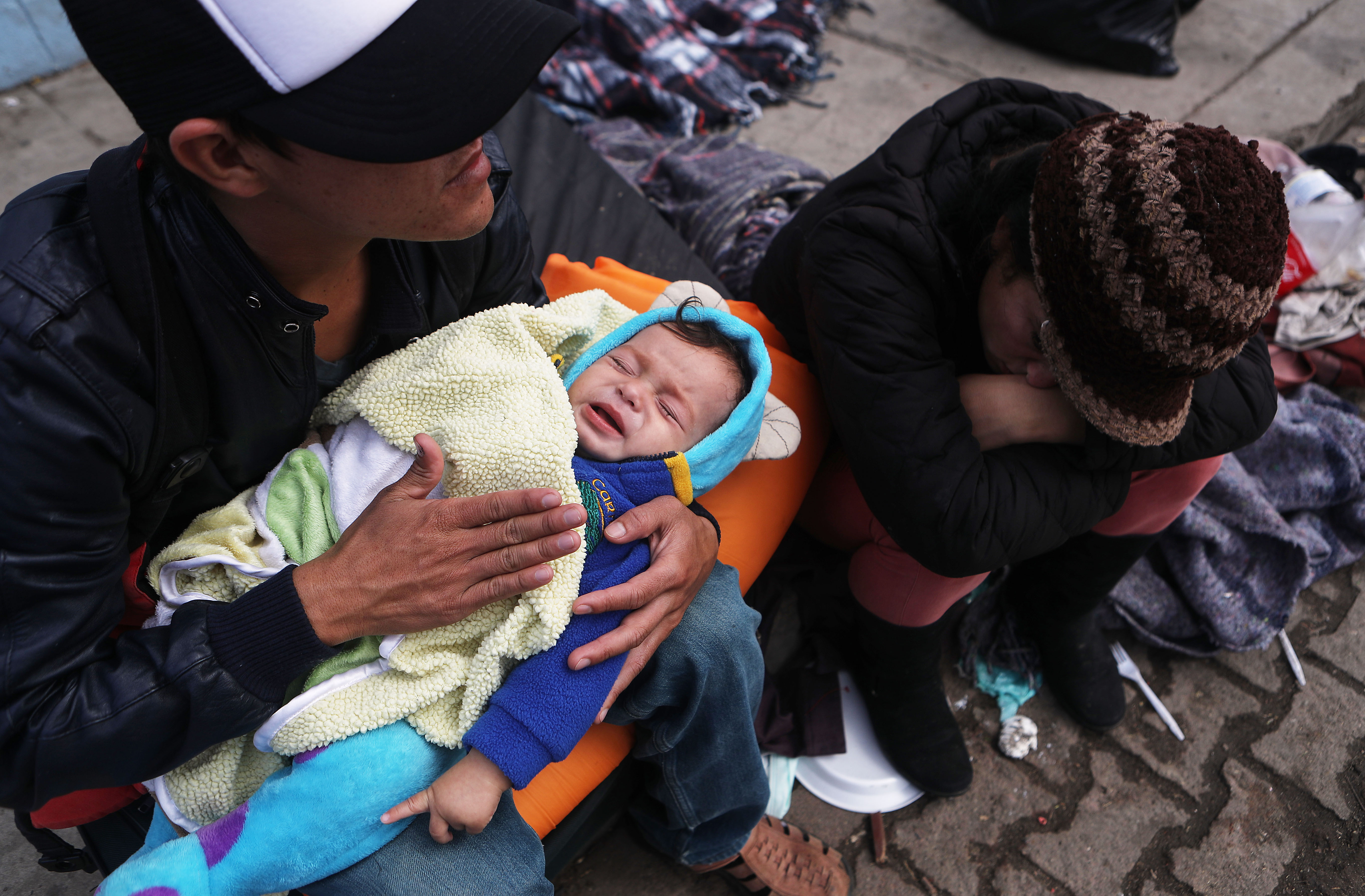 Honduran father Alexandre holds his son Karmaliel, who is sick with a fever