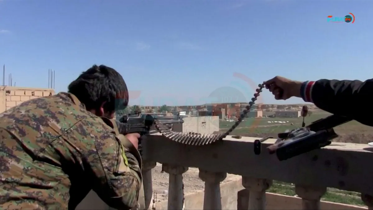 FILE PHOTO: A soldier said to be from US.-backed Syrian Democratic Forces is seen firing a rifle from a rooftop towards IS targets in Baghouz, Syria, in this screen grab taken from video said to be shot March 4, 2019, and uploaded to social media website on March 5, 2019. Social Media Website/ via REUTERS