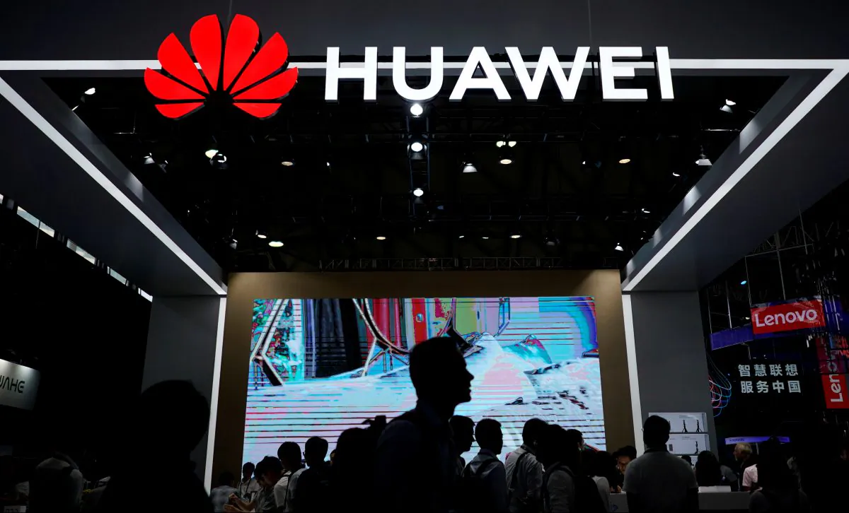 People walk past a sign board of Huawei at CES (Consumer Electronics Show) Asia 2018 in Shanghai, China Jun. 14, 2018. (Aly Song/Reuters)