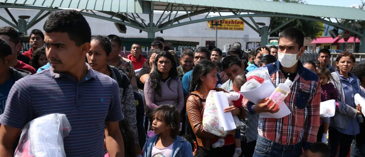 Undocumented immigrants just released from detention through "catch and release" immigration policy stand at a bus station before being taken to the Catholic Charities relief center in McAllen, Texas, on April 11, 2018. (Loren Elliott/Reuters)
