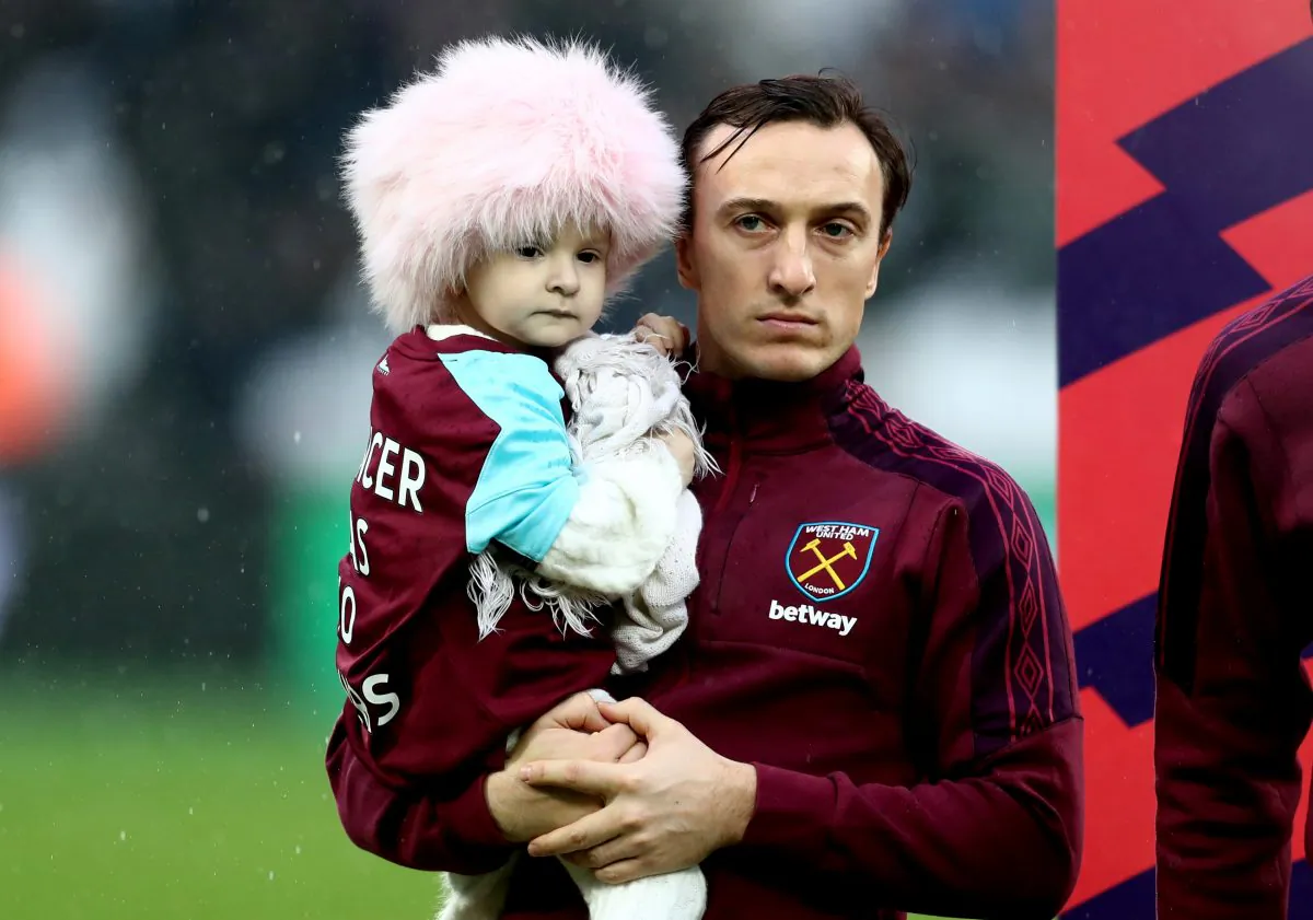 Mark Noble of West Ham United holds Isla Caton as he lines up prior to the Premier League match between West Ham United and AFC Bournemouth at London Stadium in London, UK, on Jan. 20, 2018. (Catherine Ivill/Getty Images)