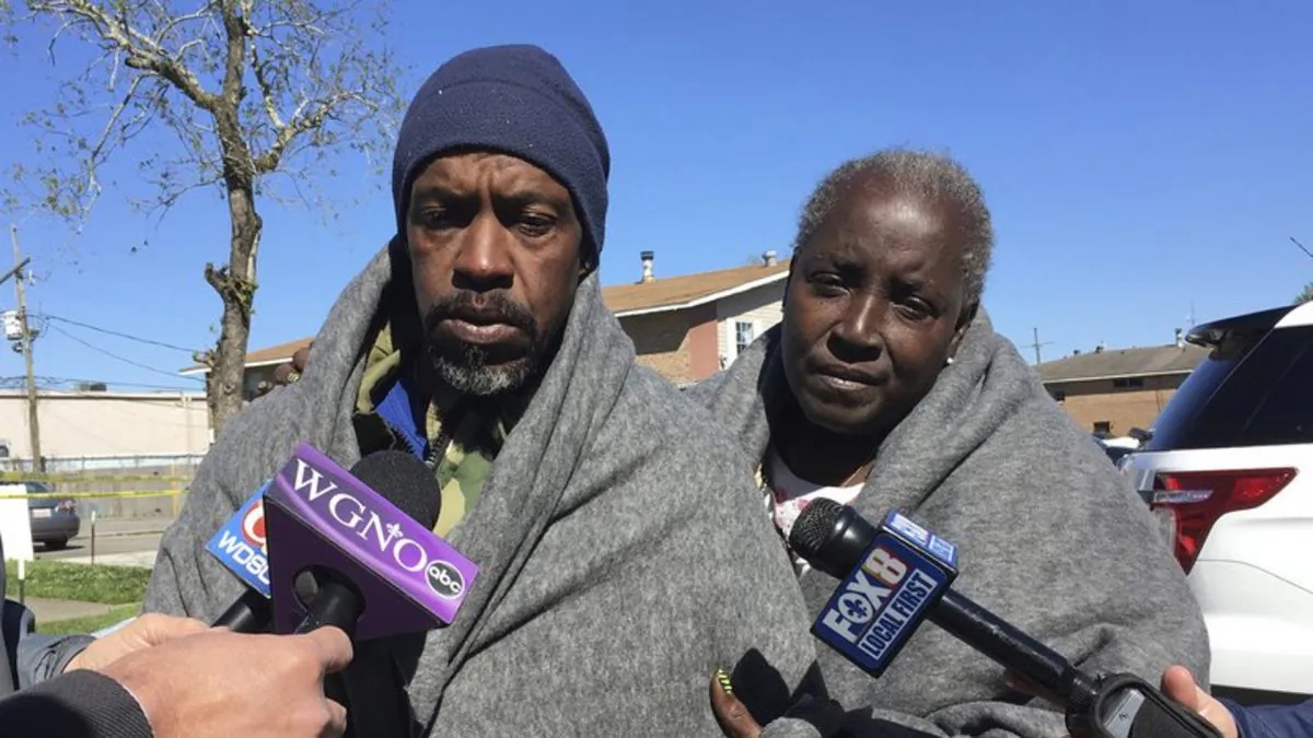 Emmett Rhodes, left, and neighbor Willie Tyson stand outside a house where authorities found a woman and two children killed and another woman and child critically injured in Terrytown, La., on March 6, 2019. (Kevin McGill/AP Photo)