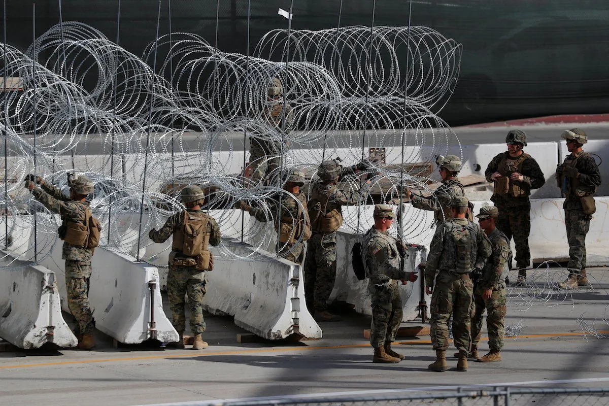 U.S. Marines help to build a concertina wire barricade at the U.S. Mexico border in preparation for the arrival of a caravan of migrants at the San Ysidro border crossing in San Diego, Calif., on Nov. 13, 2018. (Reuters/Mike Blake)

