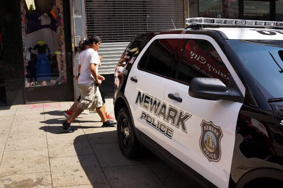People walk by a police car in downtown in Newark, New Jersey. on May 13, 2014 . (Photo by Spencer Platt/Getty Images)