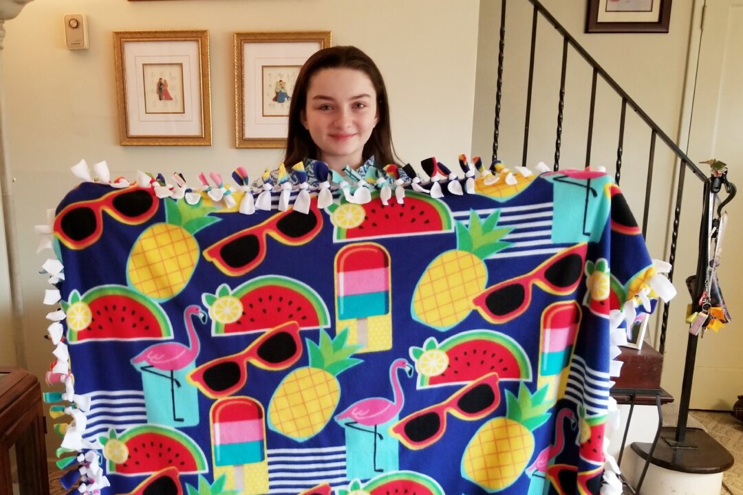 Meredith Kass, a senior at Kellenberg Memorial High School in Uniondale, N.Y., holds a Meredith's Favorite Blanket to help those in need. (Photo by Rolyne Joseph)