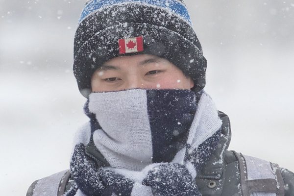 Snow lands on a person's hat as snow falls in Kingston, 