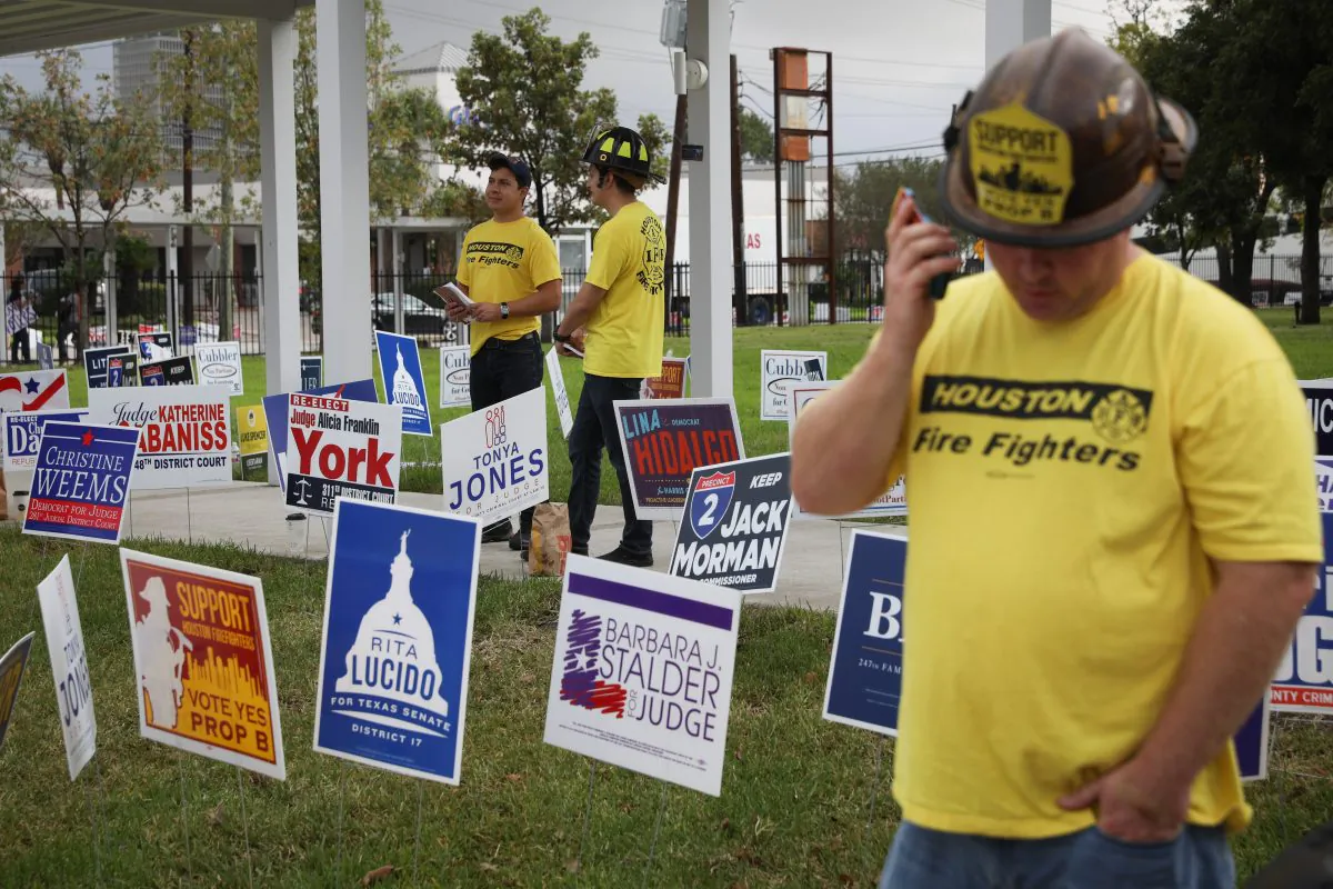 Firefighters encourage voters to vote on a proposition that would raise their pay outside the Metropolitan Multi-Service Center polling place on Nov. 6, 2018 in Houston. (Loren Elliott/Getty Images)