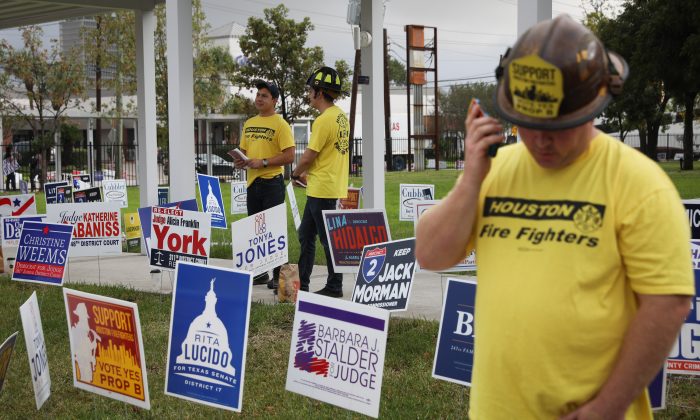 Firefighters encourage voters to vote on a proposition that would raise their pay outside the Metropolitan Multi-Service Center polling place on Nov. 6, 2018 in Houston. (Loren Elliott/Getty Images)