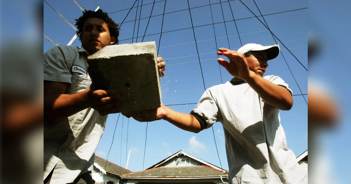 Immigrant laborers Jose (R) from Mexico and Christian from Honduras perform 'house leveling' work on a home damaged by Hurricane Katrina Apr. 27, 2006 in New Orleans. (Mario Tama/Getty Images)