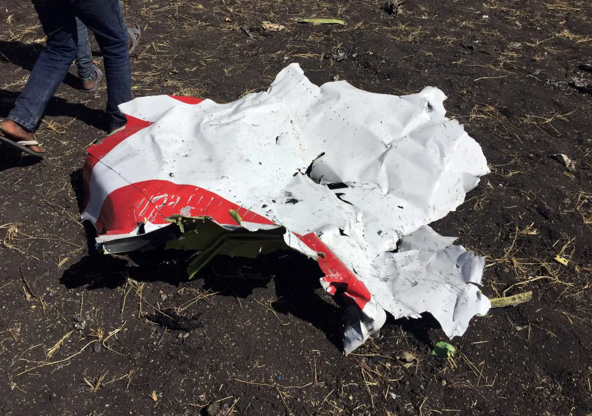 People walk past a part of the wreckage at the scene of the Ethiopian Airlines Flight ET 302 plane crash, near the town of Bishoftu, southeast of Addis Ababa, Ethiopia, on March 10, 2019. (Tiksa Negeri/Reuters)