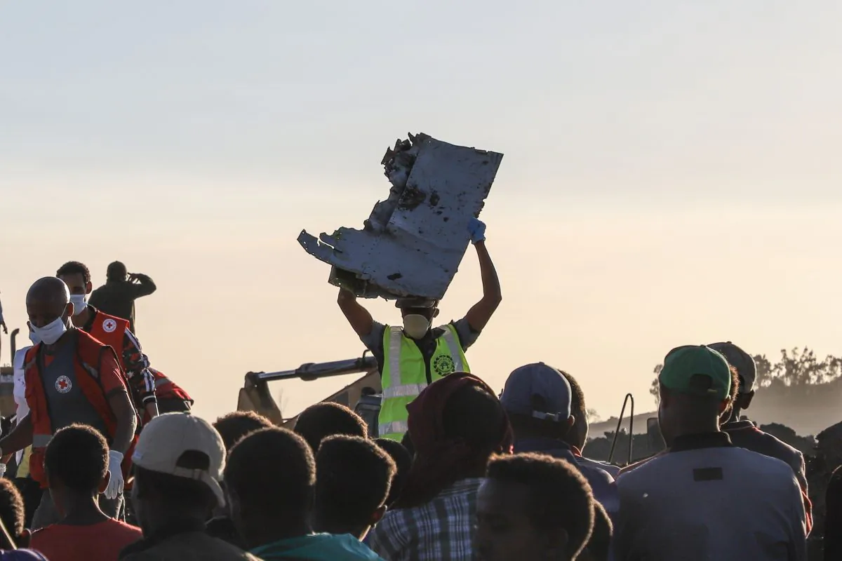 A man carries a piece of debris on his head at the crash site of a Nairobi-bound Ethiopian Airlines flight near Bishoftu, a town some 60 kilometres southeast of Addis Ababa, Ethiopia, on March 10, 2019. - A Nairobi-bound Ethiopian Airlines Boeing crashed minutes after takeoff from Addis Ababa on March 10, killing all eight crew and 149 passengers on board, including tourists, business travellers, and "at least a dozen" UN staff. (Photo by Michael TEWELDE / AFP)        (Photo credit should read MICHAEL TEWELDE/AFP/Getty Images)