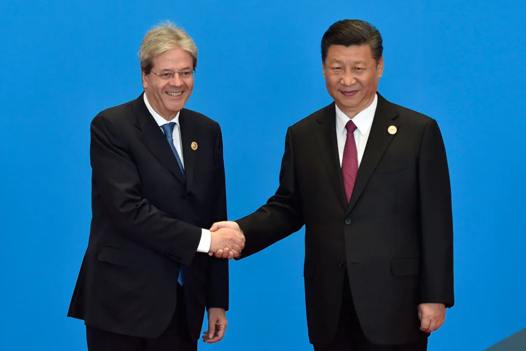 Former Italy's Prime Minister Paolo Gentiloni (L) shakes hands with Chinese leader Xi Jinping during the welcome ceremony for the Belt and Road Forum in Beijing, on May 15, 2017. (Kenzaburo Fukuhara/AFP/Getty Images)