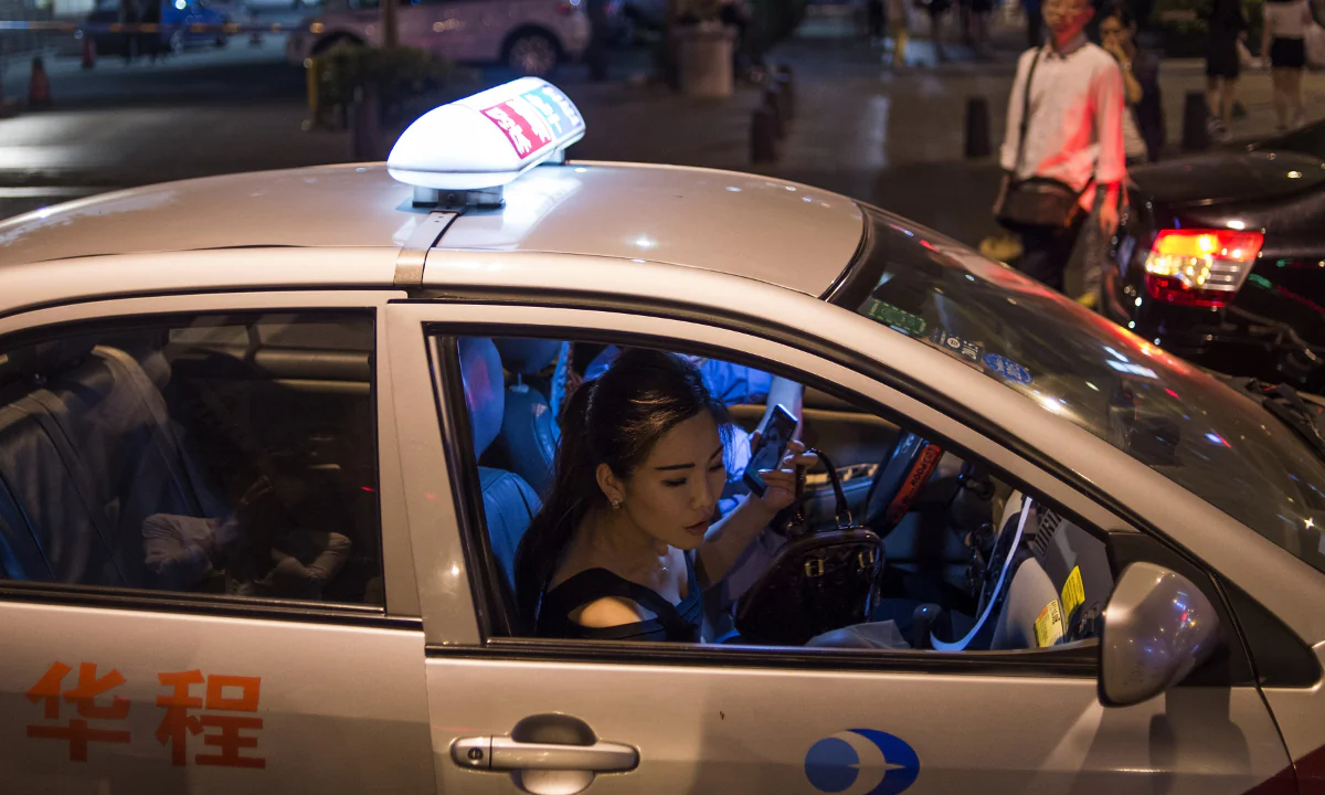 A woman exiting a taxi in China. (Fred Dufour/AFP/Getty Images)