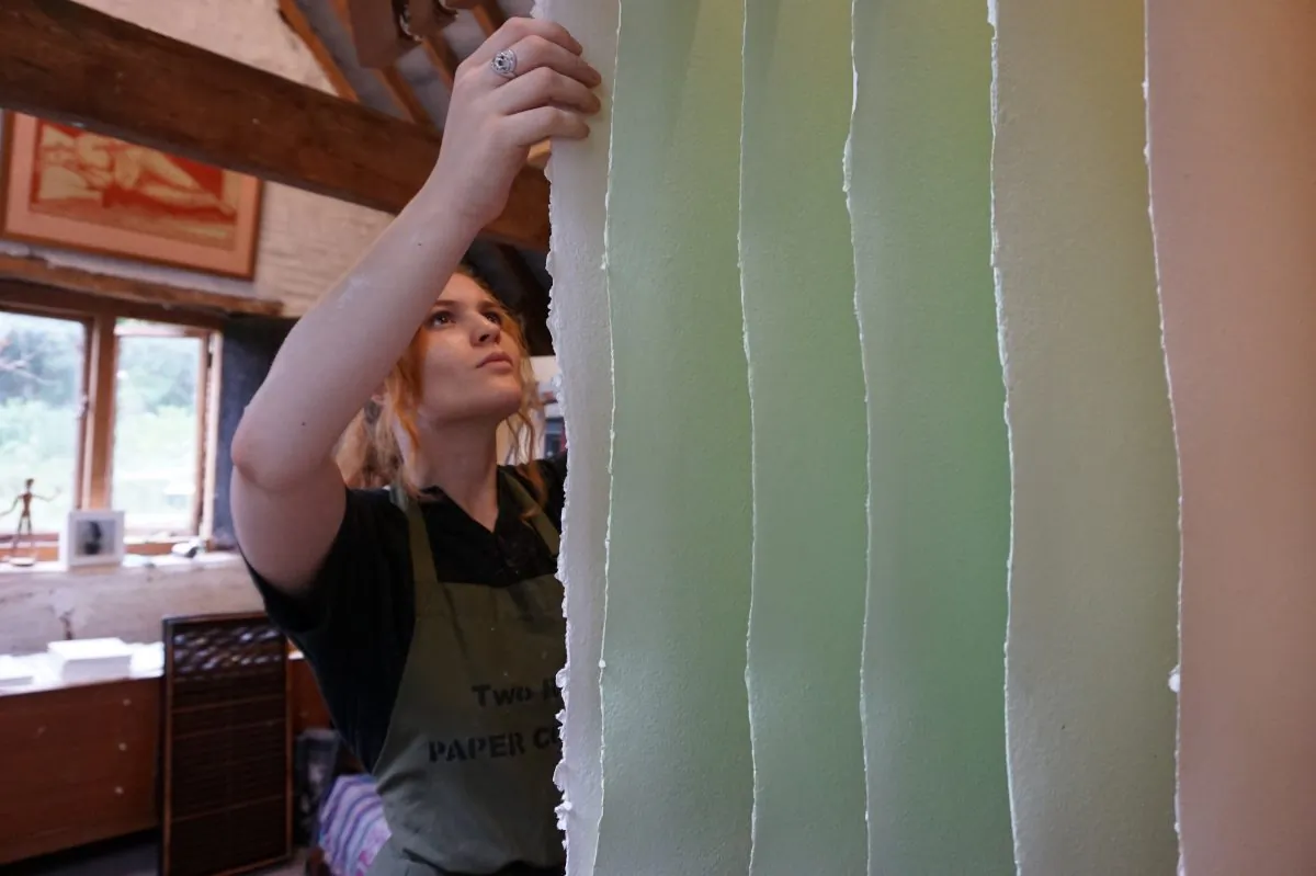 Apprentice paper maker Zoe Collis hangs paper at Two Rivers Paper in Somerset, England. (Alison Jane Hoare)