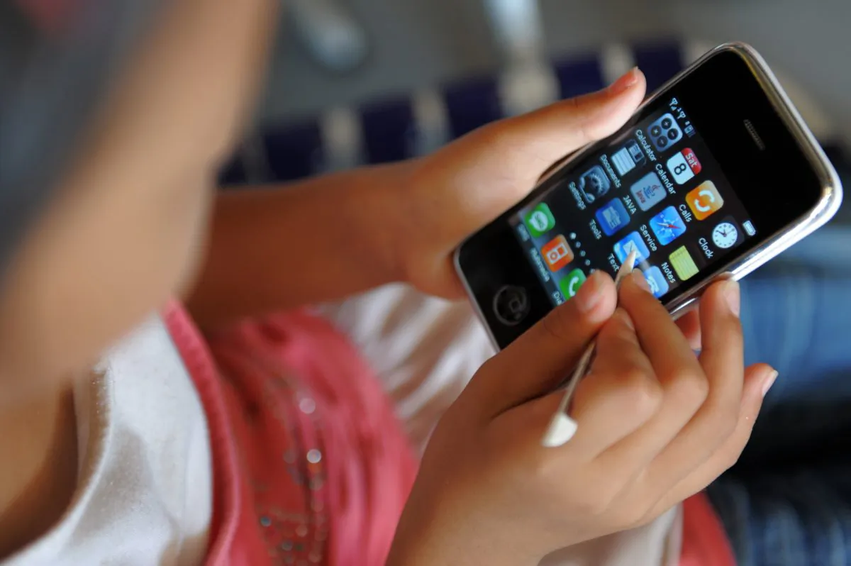 A young girl uses a cellphone in this file photo. In a statement made March 12, 2019, Ontario Education Minister Lisa Thompson said the Ontario government is planning to ban cellphones in classrooms. (Tang Chhin Sothy/AFP/Getty Images)
