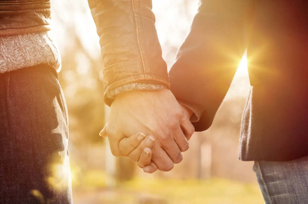 File photo of two people holding hands. (Ridofranz/iStock)