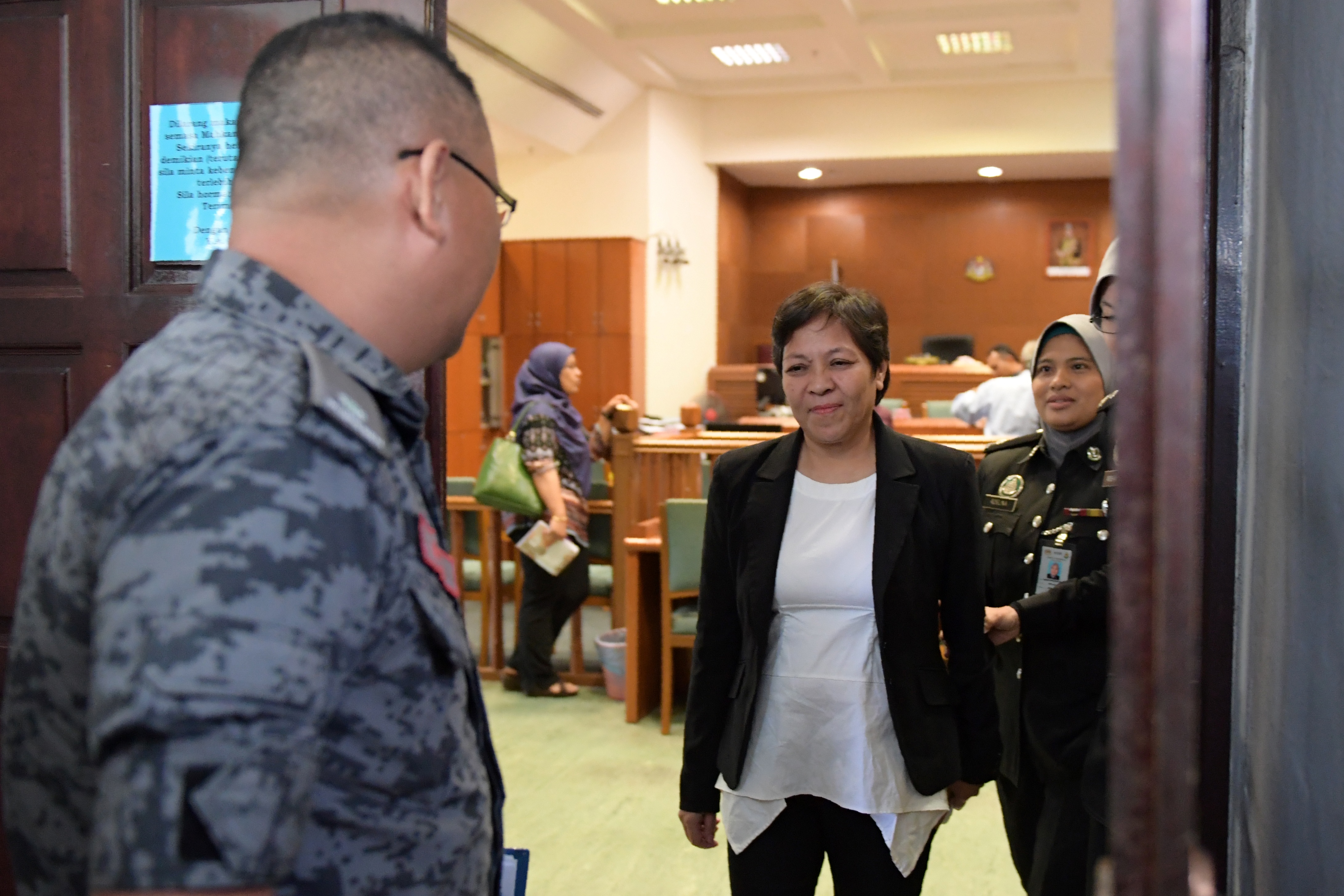 Maria Elvira Pinto Exposto is escorted upon her departure