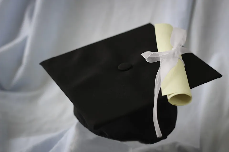Stock photo of a diploma and graduation cap. (Vloveland/Pixabay)