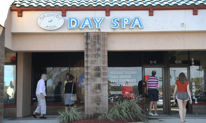 People mill around in front of the Orchids of Asia Day Spa in Jupiter, Florida, on Feb. 22, 2019. The former owner of the spa was recently revealed to have sought out opportunities to network with Republican Party politicians. (Joe Raedle/Getty Images)