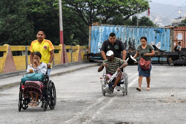 People are wheeled across the Simon Bolivar International Bridge