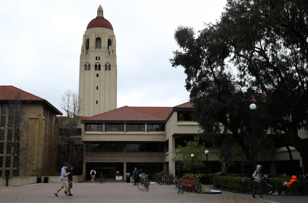 People walk by Hoover Tower on the Stanford University campus on March 12, 2019 in Stanford, California. More than 40 people, including actresses Lori Loughlin and Felicity Huffman, have been charged in a widespread elite college admission bribery scheme. Justin Sullivan/Getty Images