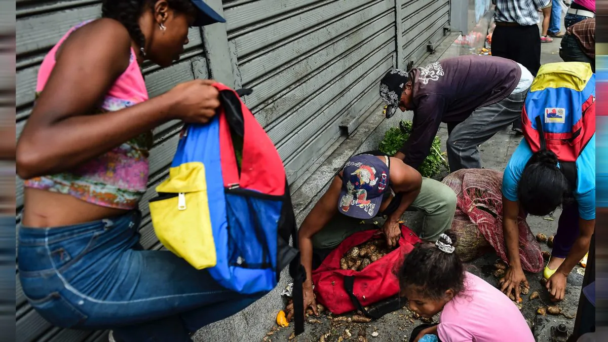 People collect food from the floor after a street market was looted in Caracas, on March 10, 2019. (Ronaldo Schemidt/AFP/Getty Images)