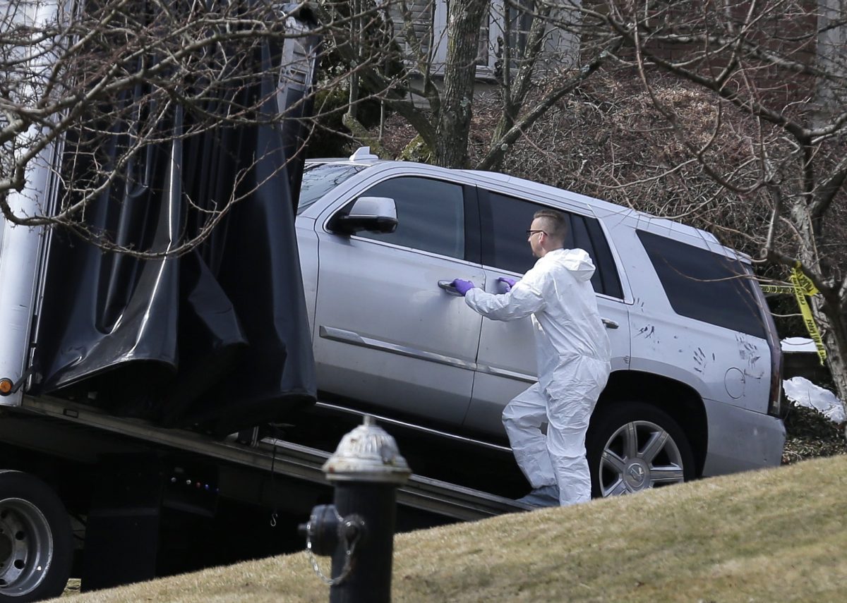 Crime scene investigators load a car