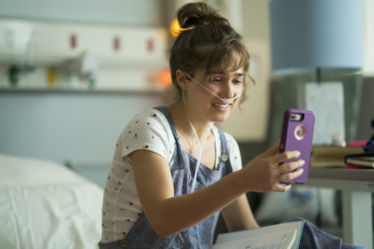 girl with cell phone in hospital bed