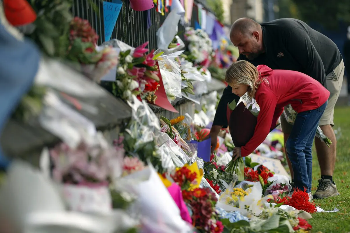 Mourners lay flowers on a wall at the Botanical Gardens in Christchurch, New Zealand, on March 16, 2019. (AP Photo/Vincent Thian)