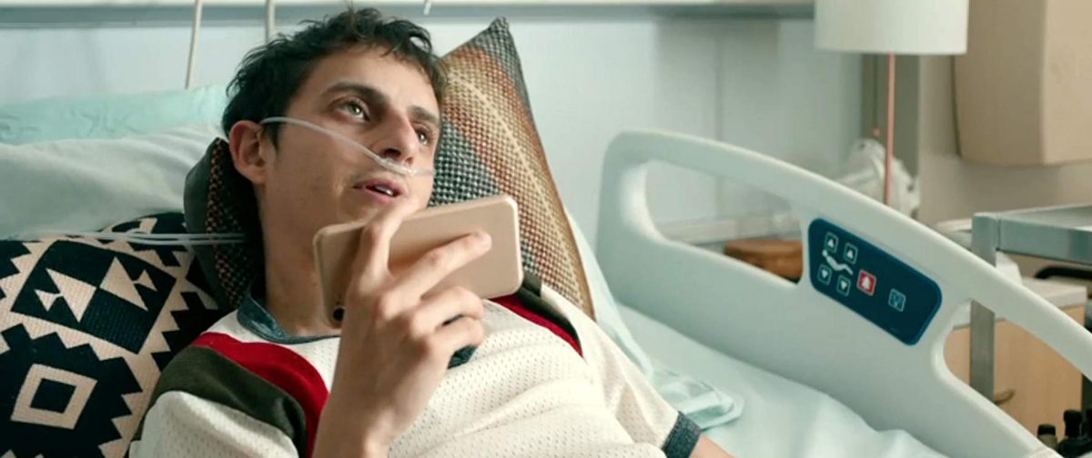 boy in hospital bed with phone