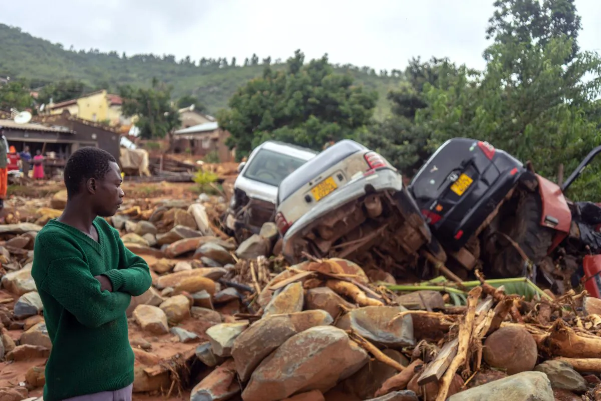 A man stands next to the wreckage of vehicles washed away on March 18, 2019, in Chimanimani, eastern Zimbabwe, after the area was hit by the cyclone Idai. (Zinyange Auntony/AFP/Getty Images)