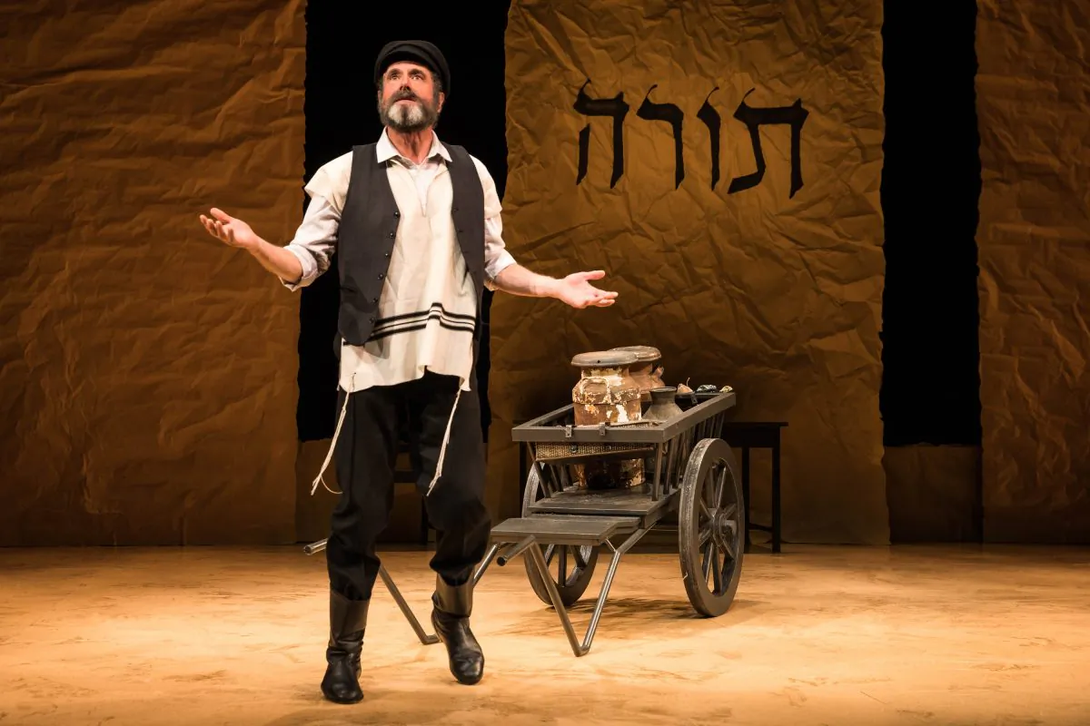 Tevye (Steven Skybell) and his milkcart, in the Yiddish production of “Fiddler on the Roof” directed by Joel Grey. (Matthew Murphy)