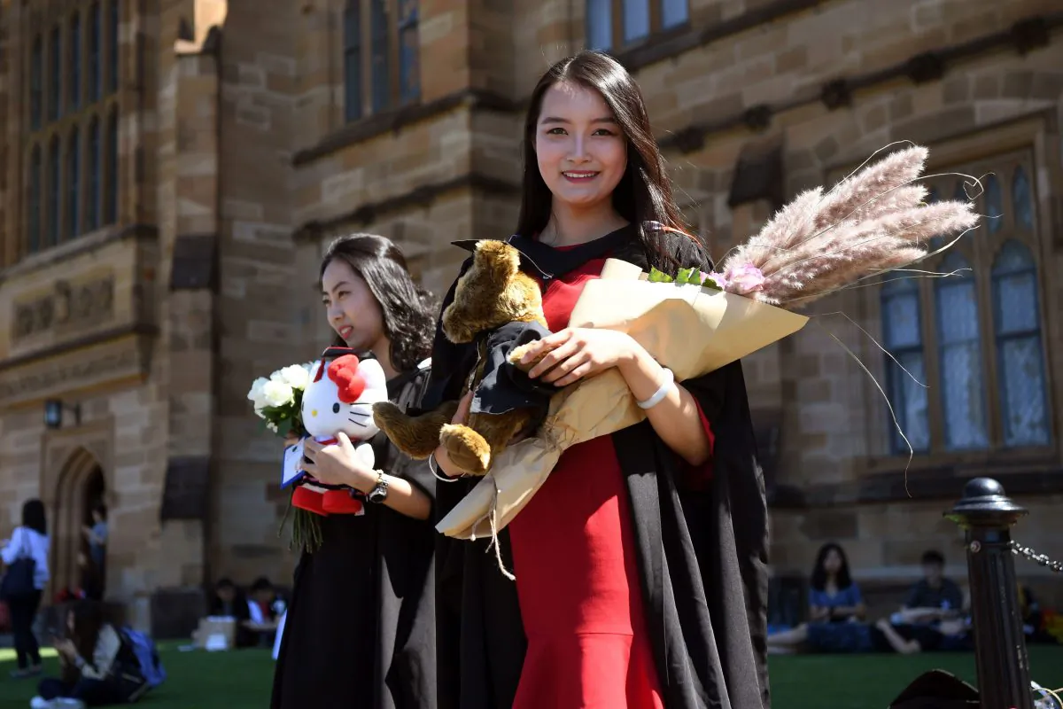 Student Zheng Zizan from Xian in China poses for family photos after graduating with a Masters of Commerce from Sydney University on Oct. 12, 2017.
(William West/AFP/Getty Images)