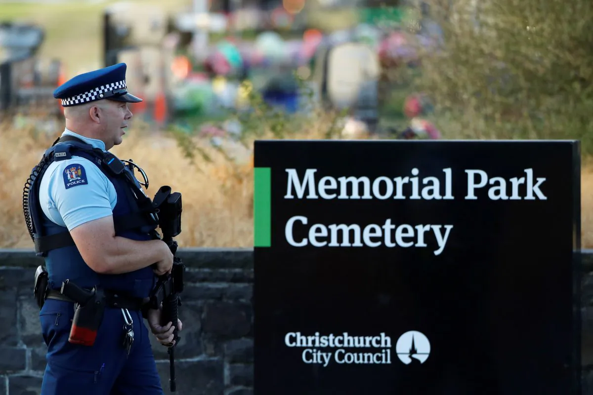 An armed policeman stands guard as the burial ceremony of the victims of the mosque attacks, at the Memorial Park Cemetery in Christchurch, New Zealand, on March 20, 2019. (Jorge Silva/Reuters)